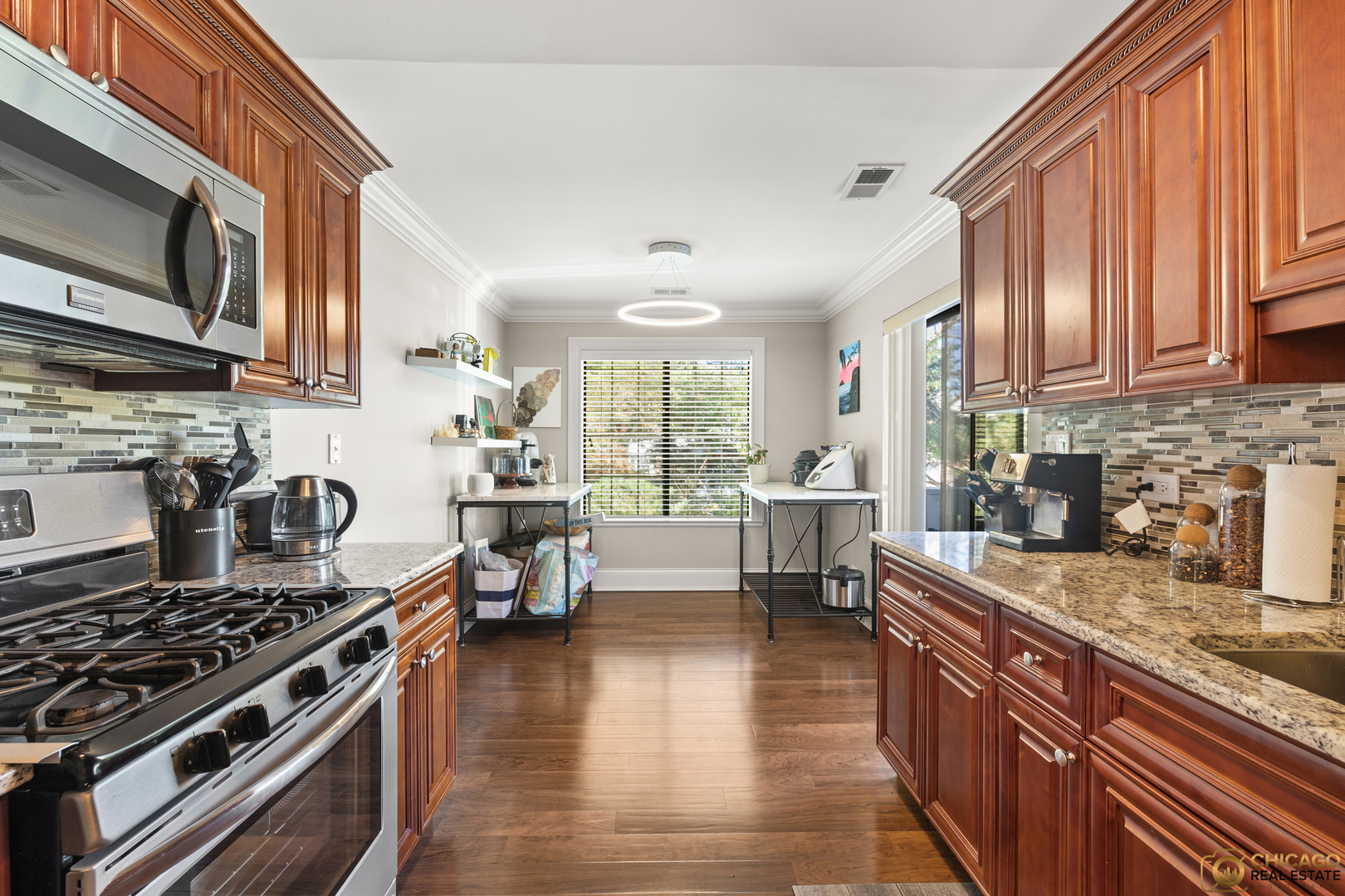 1631 West Partridge Court, Unit 8 Arlington Heights, IL 60004 - Photo 7 of 26 a kitchen with stainless steel appliances granite countertop a stove top oven a sink dishwasher a dining table and chairs with wooden floor