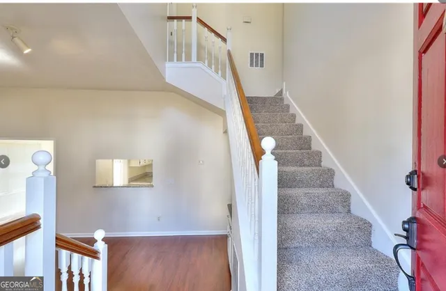 a view of entryway and hall with wooden floor