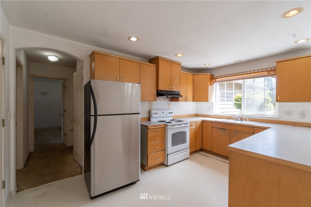10837 4th Avenue South Seattle, WA 98168 - Photo 11 of 25 a kitchen with stainless steel appliances granite countertop a refrigerator a stove top oven a sink and dishwasher