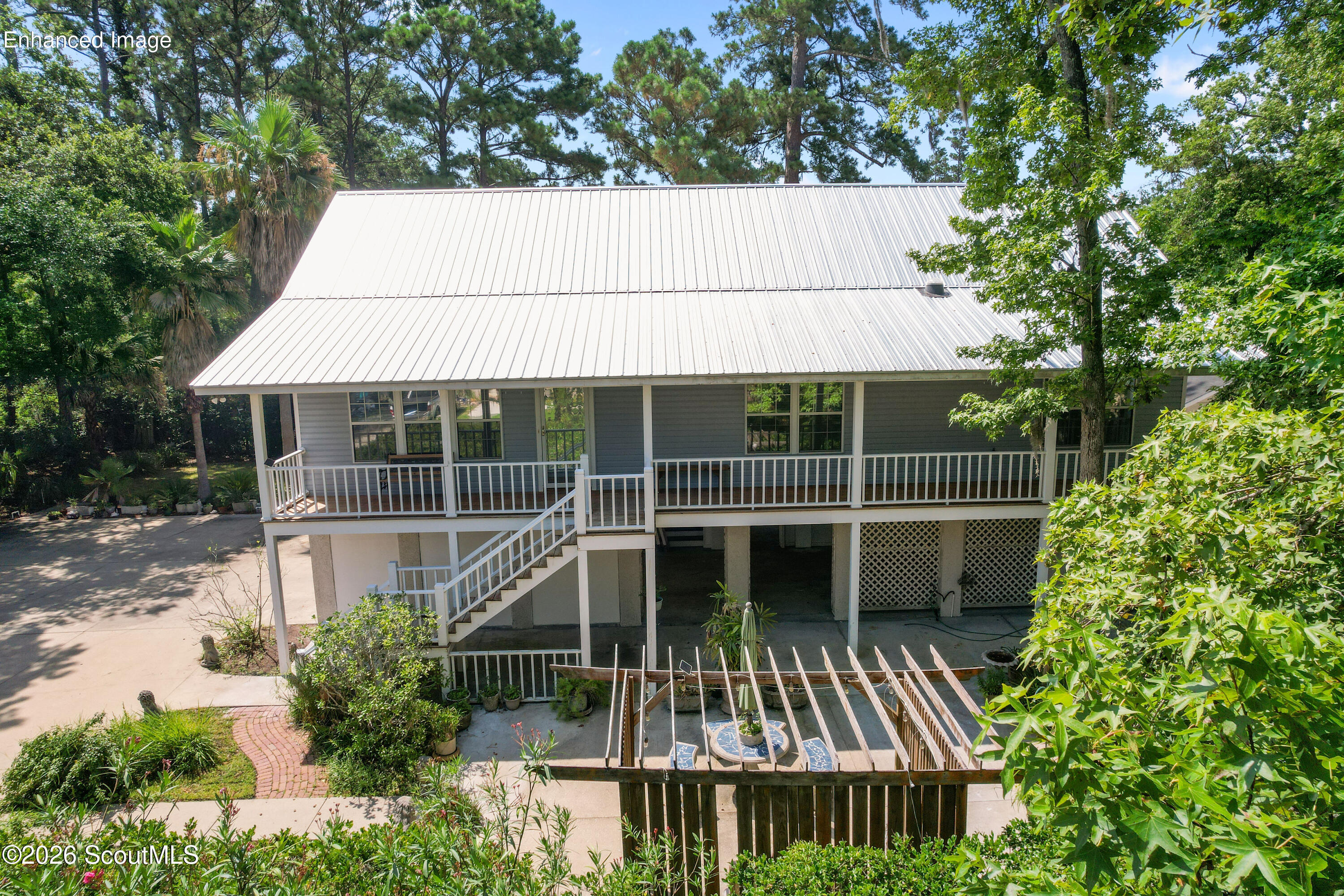 104 Sapelo Street St. Simons Island, GA 31522 - Photo 3 of 45 Newer Metal Roof and Low Country Style with Porch the entire width of the home while looking at the view of your fountain