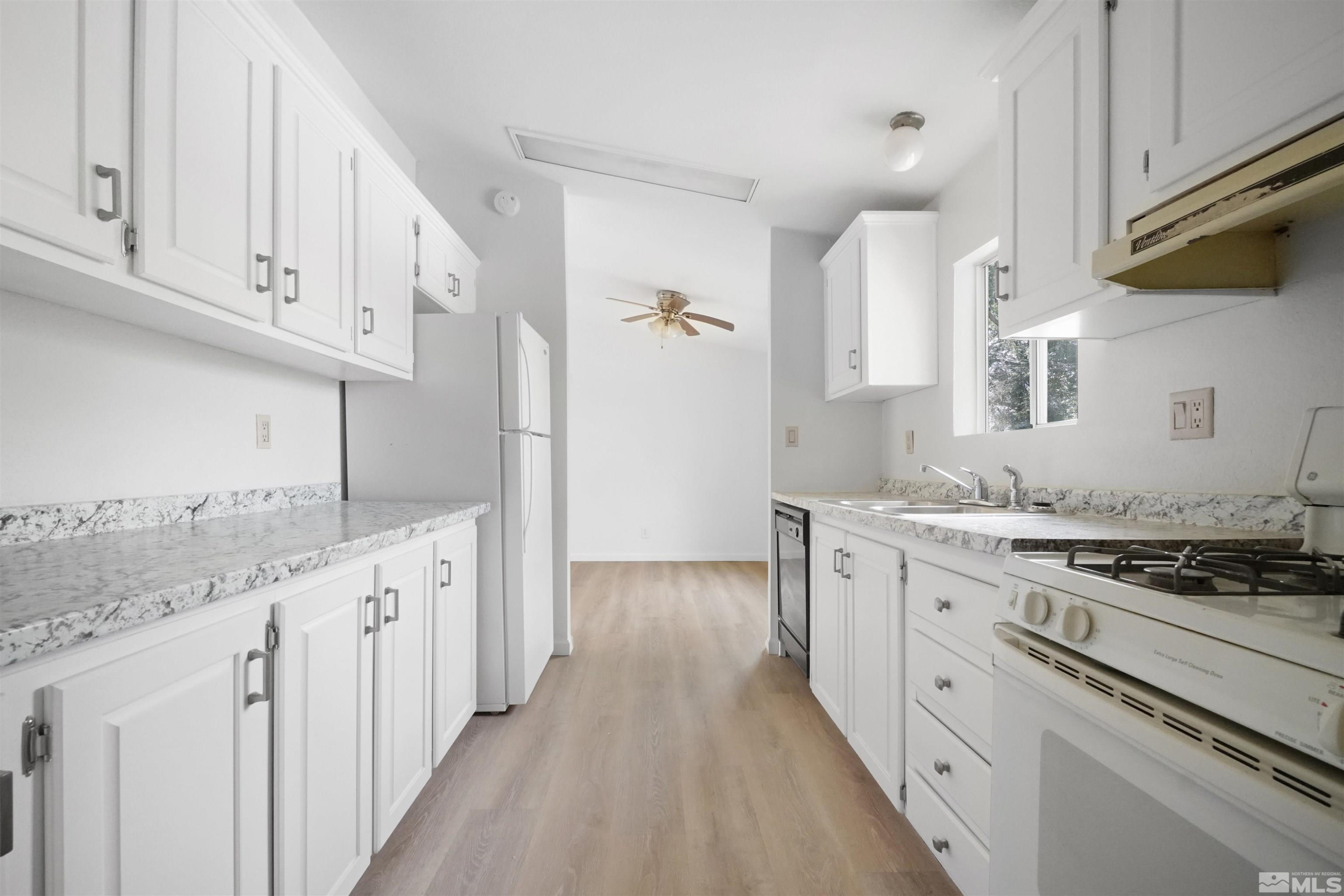15095 Pinion Drive Reno, NV 89521 - Photo 6 of 18 a kitchen with granite countertop a sink a stove and cabinets