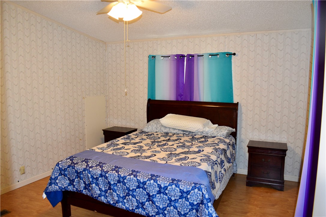 25051 Lake Shore Drive Mathis, TX 78368 - Photo 25 of 40 a bedroom with a bed and a chandelier