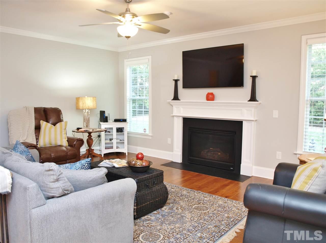 300 Bon Marche Lane Raleigh, NC 27615 - Photo 5 of 25 a living room with furniture a flat screen tv and a fireplace