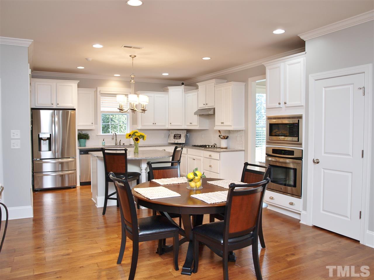 300 Bon Marche Lane Raleigh, NC 27615 - Photo 8 of 25 a kitchen with a dining table chairs and refrigerator