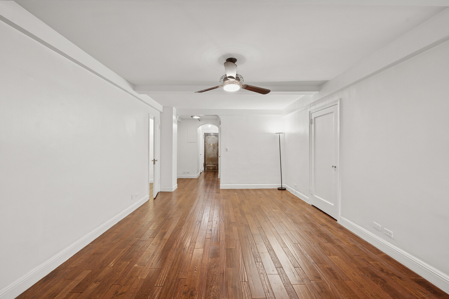 424 East 52nd Street, Unit 2D Manhattan, NY 10022 - Photo 7 of 17 a view of an empty room with wooden floor and a ceiling fan