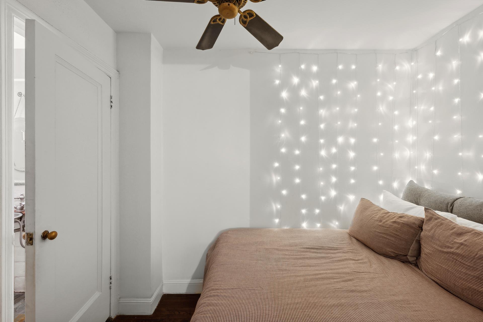 424 East 52nd Street, Unit 2D Manhattan, NY 10022 - Photo 9 of 17 a bedroom with a bed and a chandelier