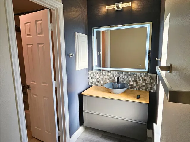 an empty room with wooden floor cabinet and a ceiling fan