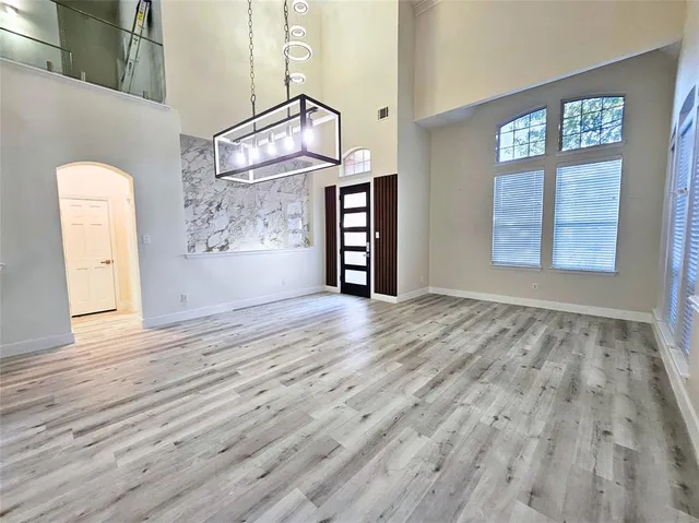 an empty room with windows and wooden floor