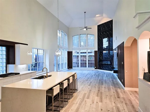 a large kitchen with stainless steel appliances a large counter top a stove a chimney a sink and a refrigerator