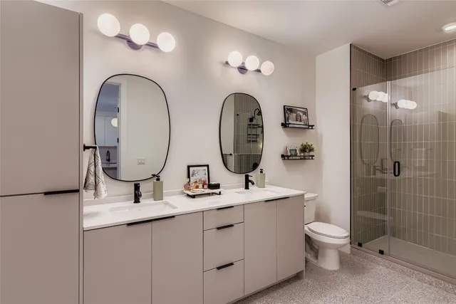 a bathroom with 2 sink toilet and shower