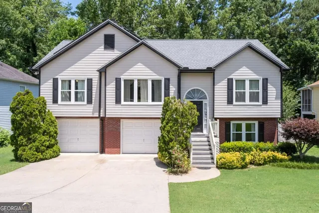 a front view of a house with a yard and potted plants