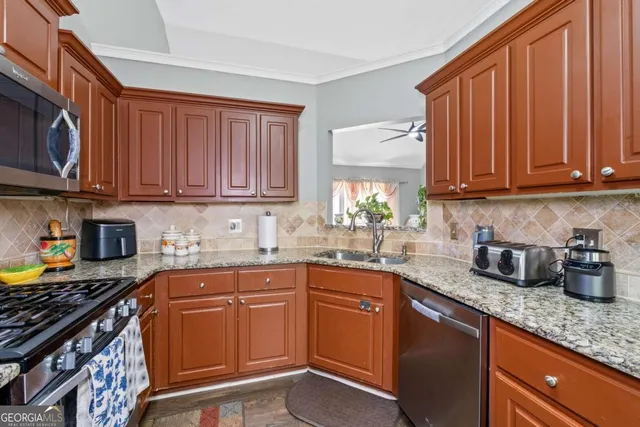 a kitchen with granite countertop a sink stove and cabinets