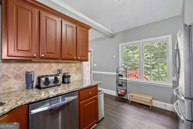a kitchen with granite countertop a stove and a wooden floors