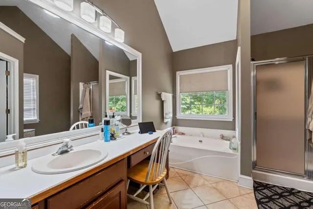 a bathroom with a granite countertop sink mirror and a bathtub