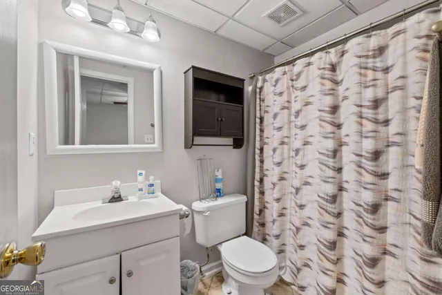 a bathroom with a sink a toilet and shower curtain