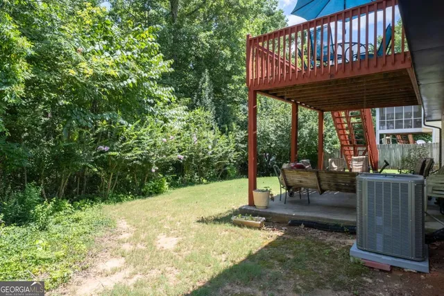 a view of a patio with a table chairs and wooden fence