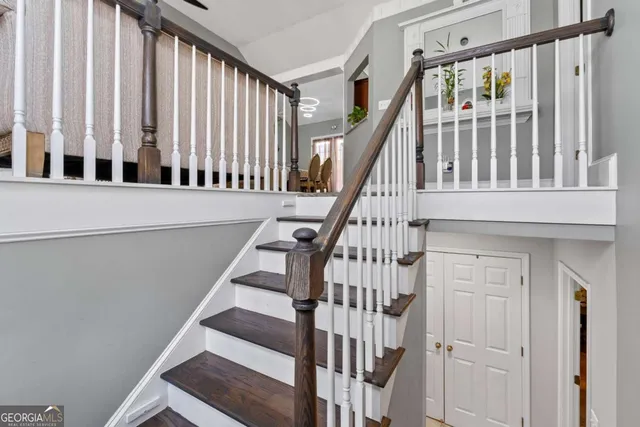 a view of staircase with railing and white walls
