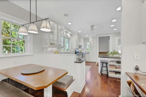 a living room with stainless steel appliances kitchen island a table and chairs in it