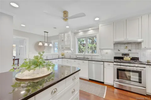 a kitchen with kitchen island granite countertop a sink a stove and cabinets