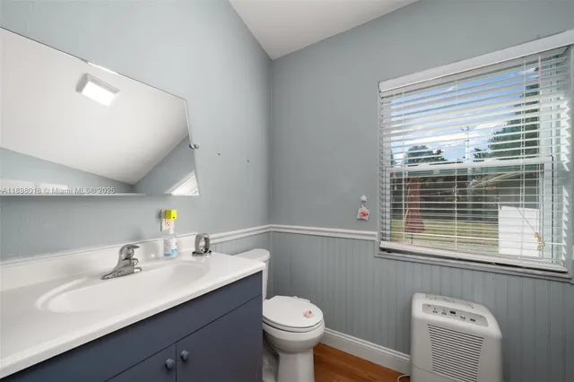 a bathroom with a sink toilet and a window