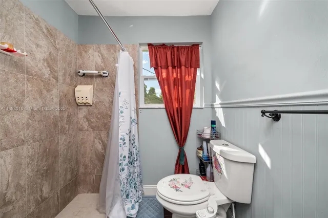 a white toilet sitting next to a shower curtain