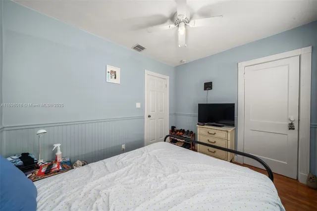 a bedroom with a bed and a flat tv screen on dresser