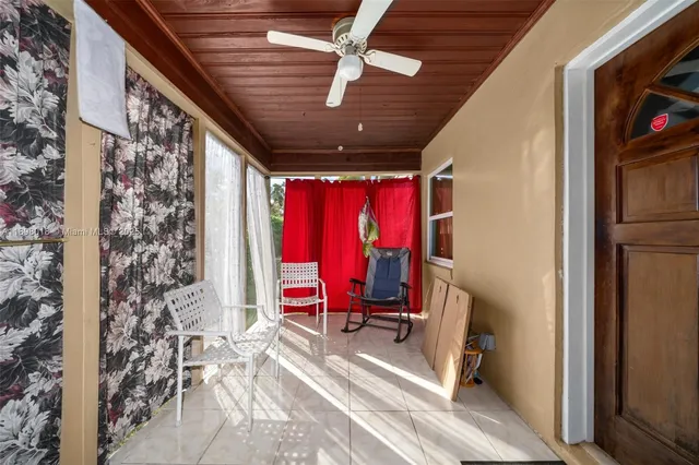 a view of a hallway with wooden floor and a ceiling fan
