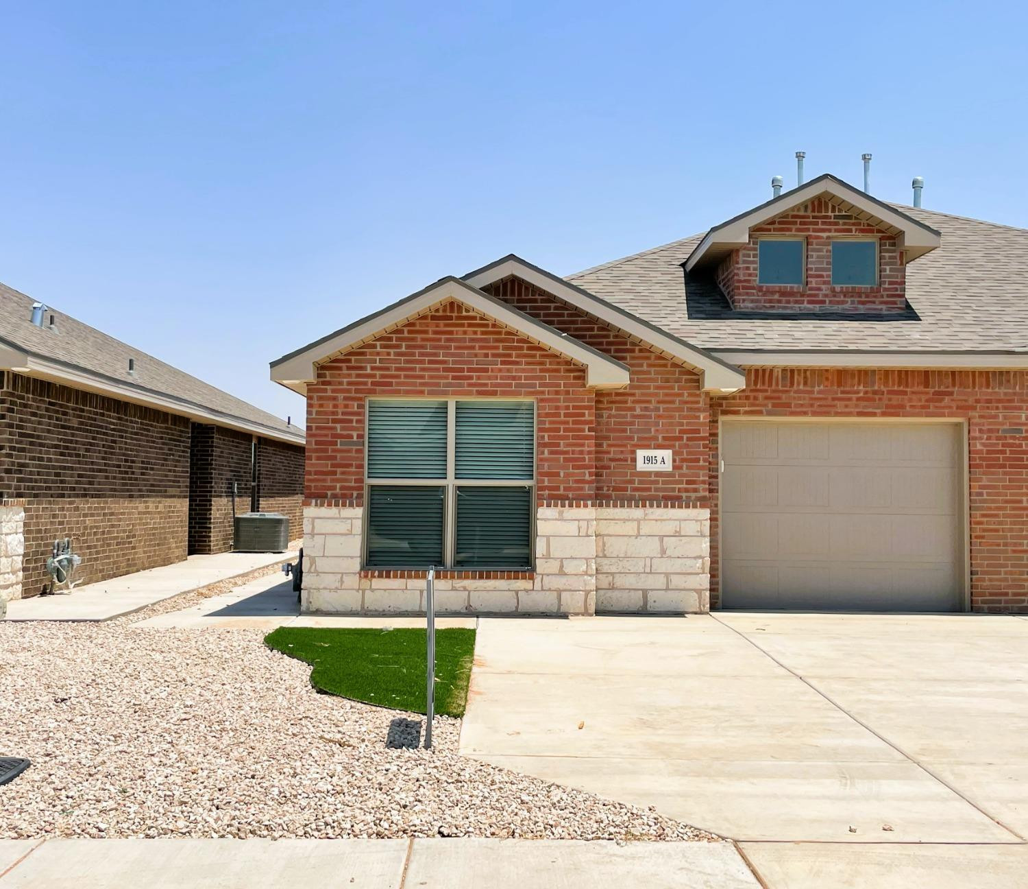 1915 Langford Avenue, Unit A Lubbock, TX 79407 - Photo 1 of 23 a front view of a house with a yard and garage