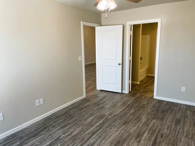 an empty room with wooden floor and closet area