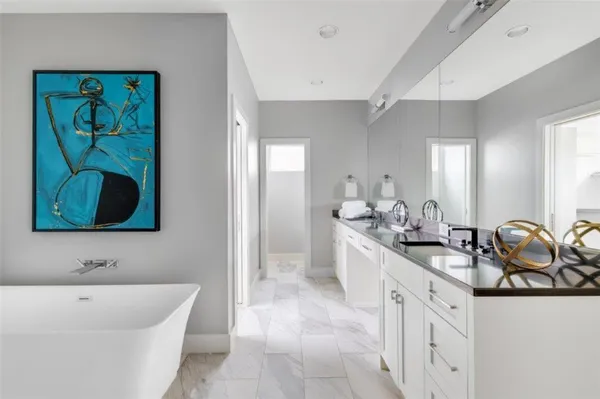 a spacious bathroom with a double vanity sink a mirror and a bathtub