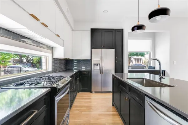 a kitchen with stainless steel appliances granite countertop a sink a stove and a refrigerator