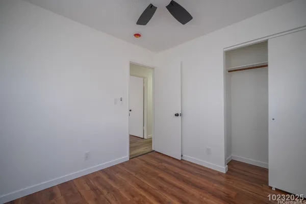 a view of a room with wooden floor and a ceiling fan