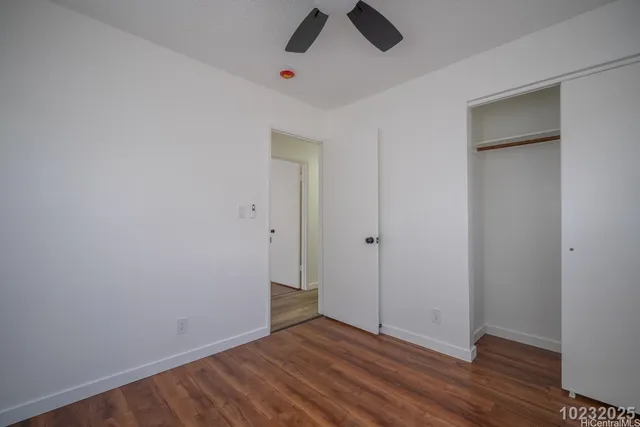 a view of a room with wooden floor and a ceiling fan