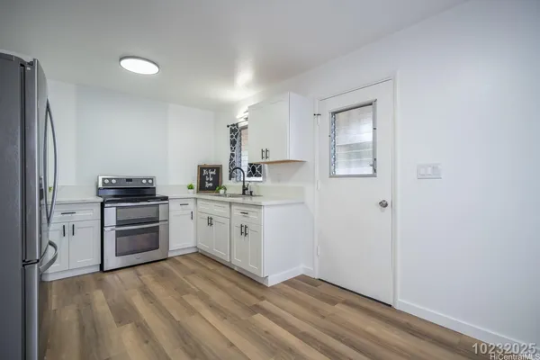 a kitchen with a refrigerator and a stove top oven