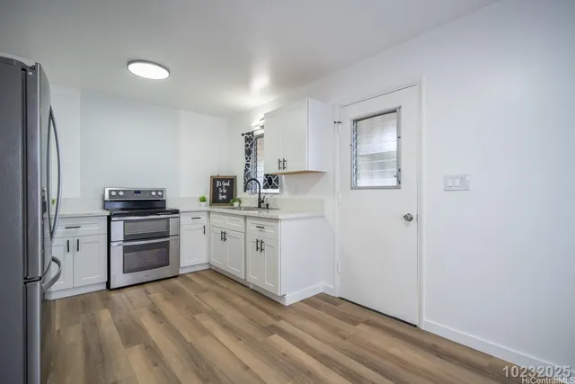 a kitchen with a refrigerator and a stove top oven