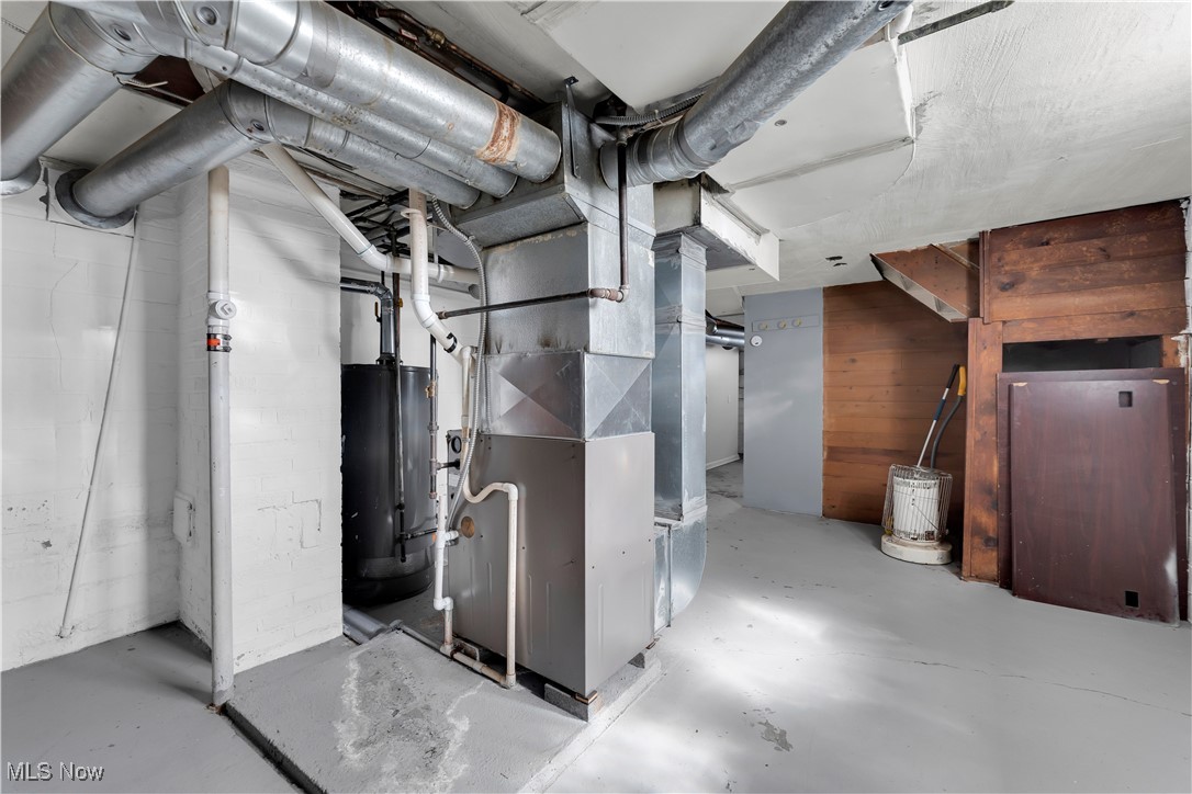 3739 Warren Road Cleveland, OH 44111 - Photo 13 of 40 Unfinished below grade area with heating unit, gas water heater, and wooden walls