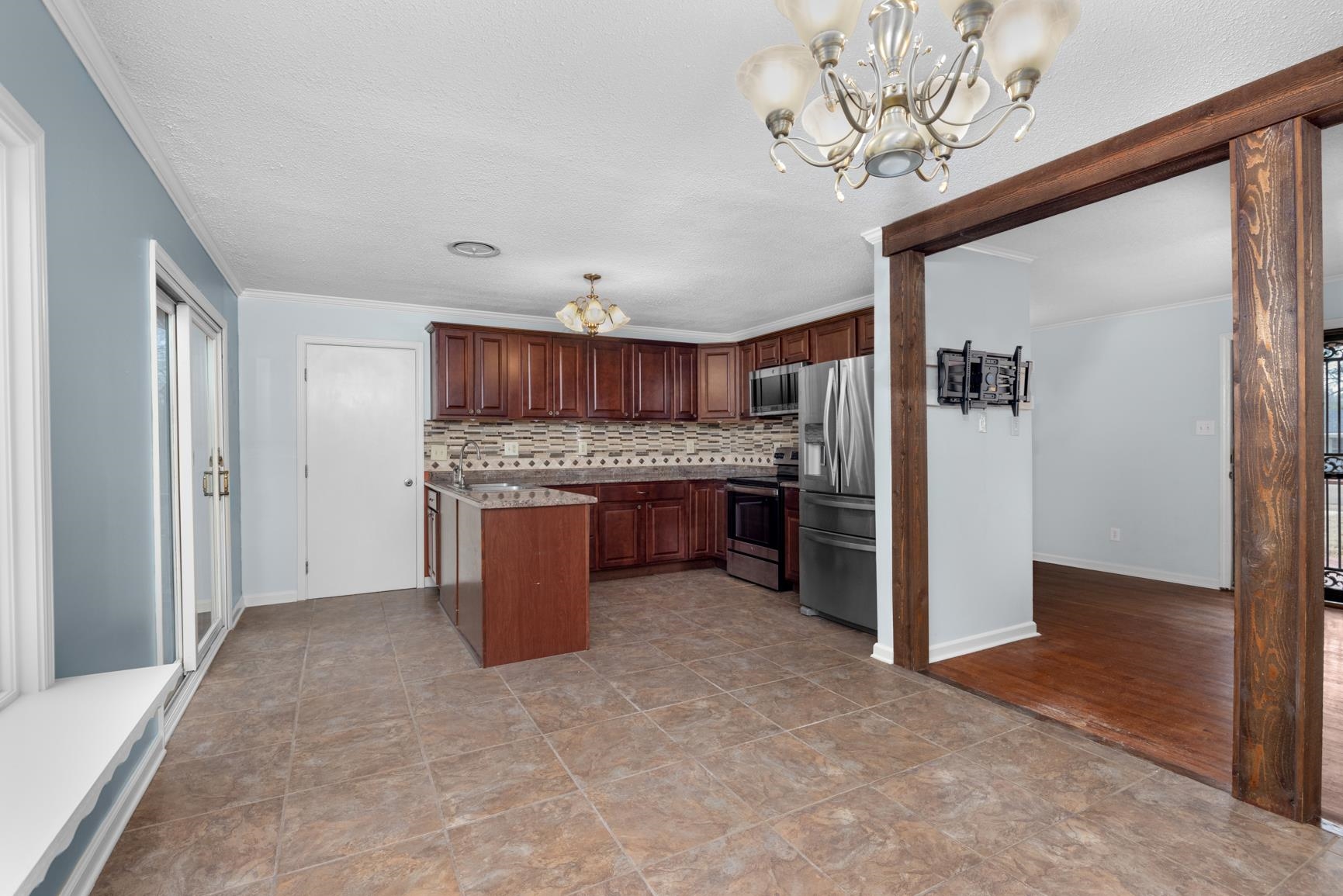 5364 Virgil Road Bartlett, TN 38134 - Photo 7 of 32 Kitchen featuring a chandelier, stainless steel appliances, pendant lighting, tasteful backsplash, and crown molding
