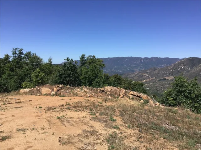 a view of a dry yard with mountains in the background