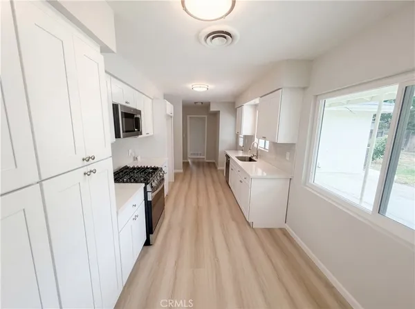a kitchen with sink a microwave and cabinets