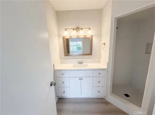 a bathroom with a sink mirror and shower
