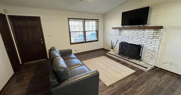 a living room with furniture a flat screen tv and a fireplace