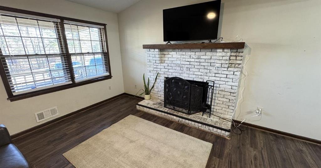 5146 Union Church Road Flowery Branch, GA 30542 - Photo 4 of 12 a living room with a fireplace and a flat screen tv