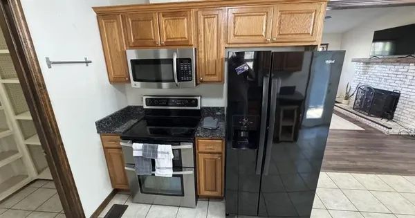 a kitchen with stainless steel appliances granite countertop a refrigerator and a stove top oven