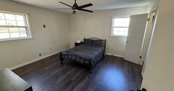 a room with a bed and wooden floor