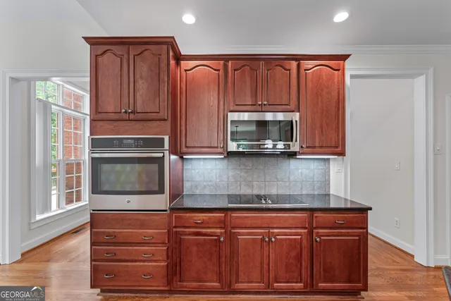 a kitchen with stainless steel appliances granite countertop a refrigerator and cabinets