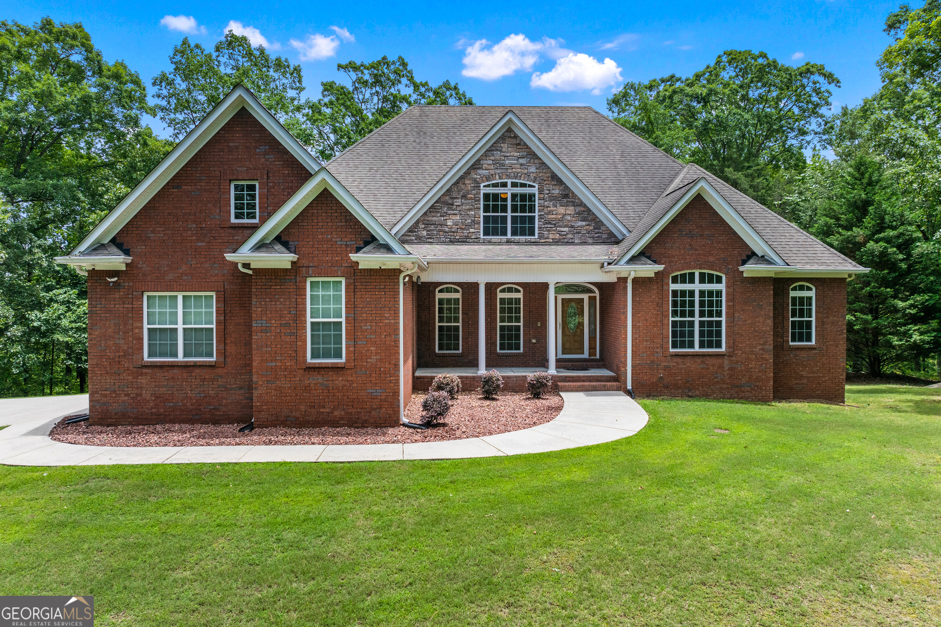 6020 Cochran Mill Road Chattahoochee Hills, GA 30213 - Photo 2 of 44 a front view of a house with a yard and garage