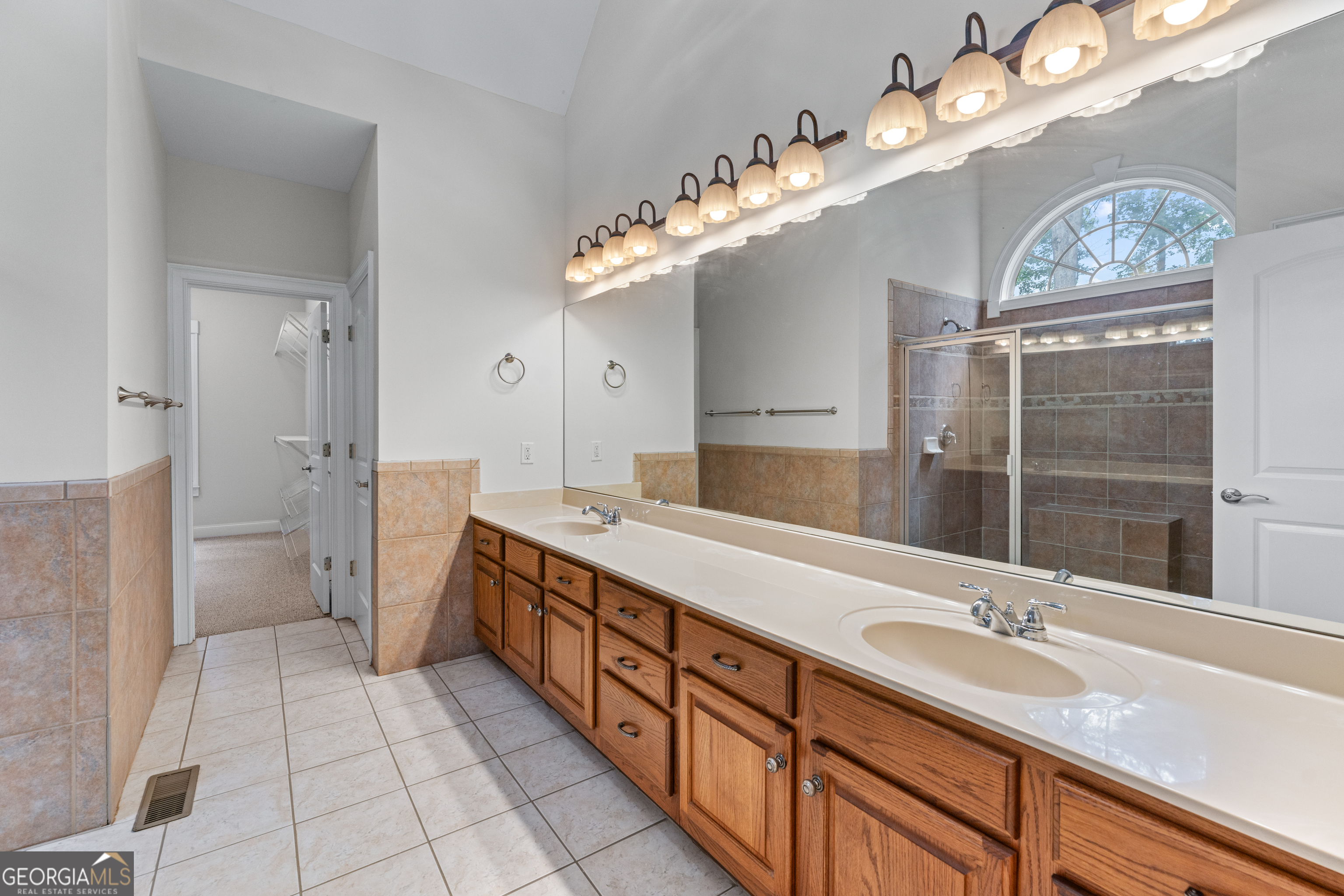 6020 Cochran Mill Road Chattahoochee Hills, GA 30213 - Photo 23 of 44 a spacious bathroom with a double vanity sink mirror and a toilet