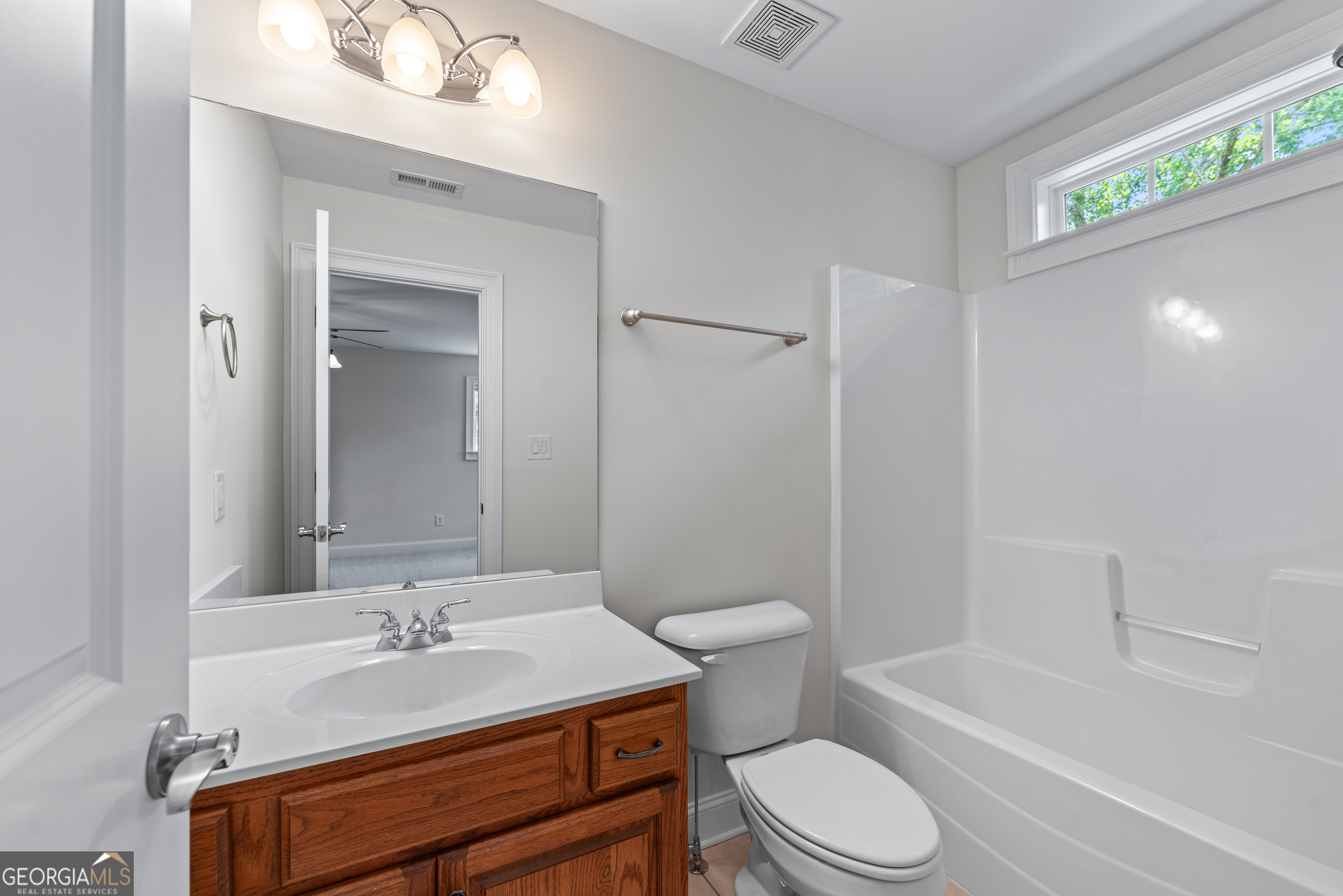 6020 Cochran Mill Road Chattahoochee Hills, GA 30213 - Photo 30 of 44 a bathroom with a sink toilet a mirror and shower