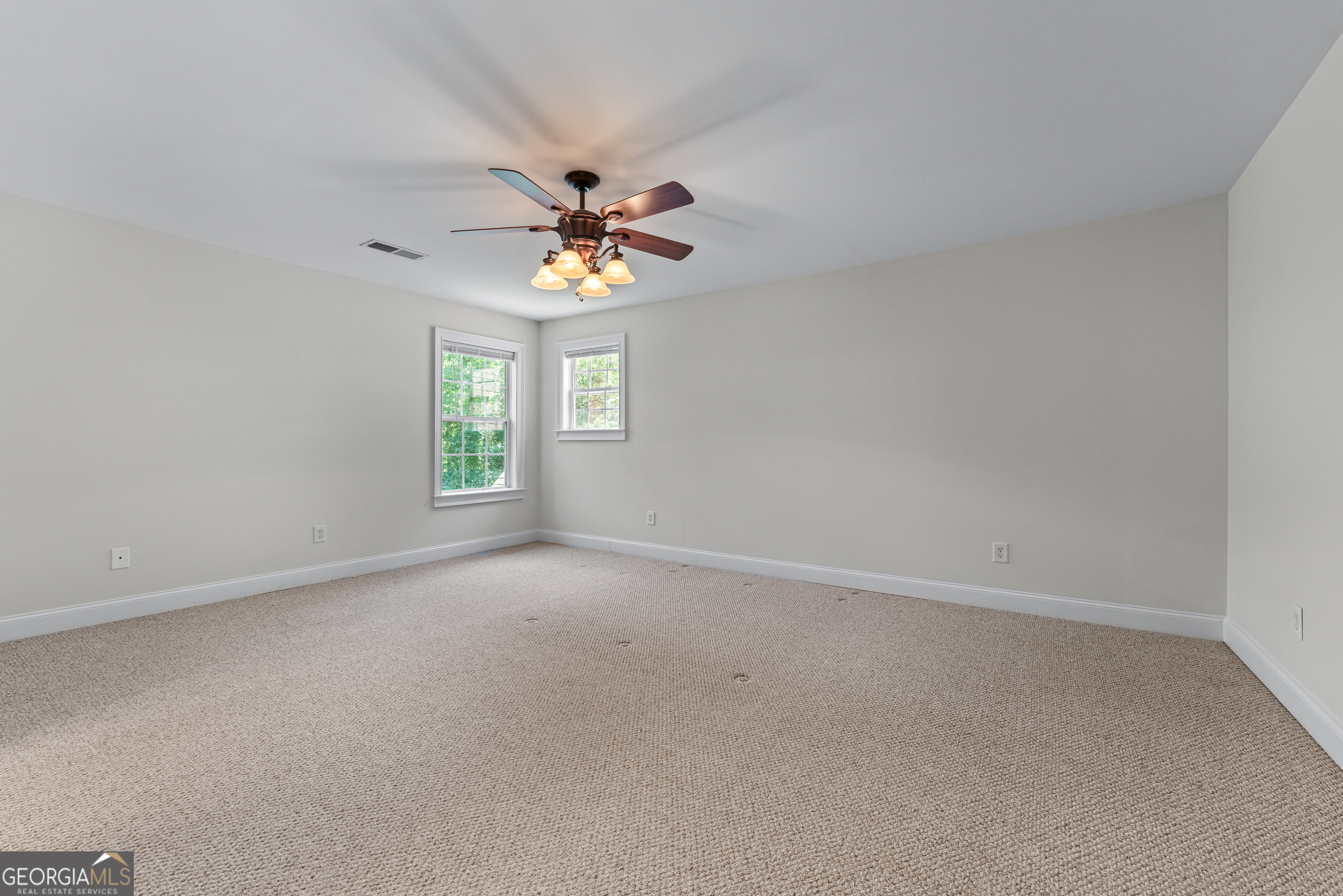 6020 Cochran Mill Road Chattahoochee Hills, GA 30213 - Photo 31 of 44 an empty room with windows and chandelier fan