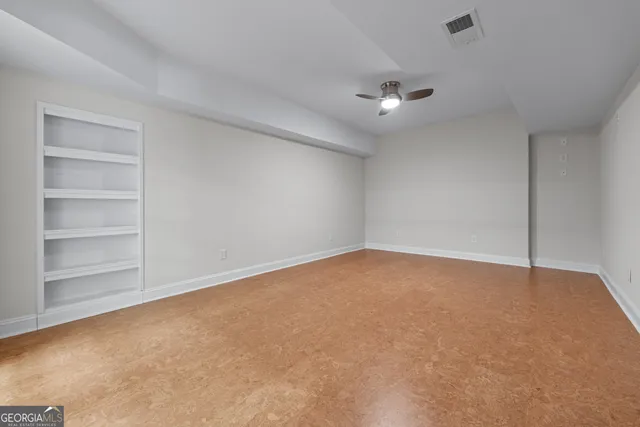 a view of an empty room with a ceiling fan